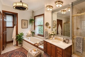 Ein Badezimmer mit einem großen Spiegel, zwei Waschbecken, einer Badewanne und einer Duschkabine.