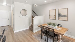 A dining area with a wooden table, chairs, and a staircase. - Family Friendly Poolside Home near Zion & Sand Hollow (Washington)