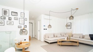 Een moderne woonkamer met een hoekbank, een ronde salontafel en een minimalistisch design.