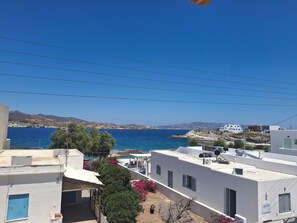 A coastal residential area with buildings, a clear blue sky, and a view of the sea. - Vilos Luxury Suites  (Milos)