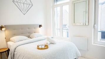 Una camera da letto con un letto, comodini, una finestra e un elemento decorativo geometrico a parete.