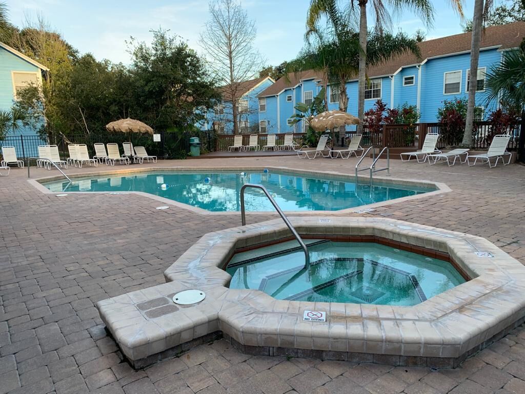 Una piscina con sillones de descanso y un jacuzzi.