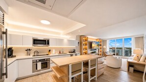 A modern kitchen with a central island, built-in appliances, and a dining area with a view. - 1-bedroom hotel suites in amazing Miami Beach with fitness room (Miami Beach)