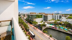 A modern hotel with a pool, a road with vehicles, and a river. - 1-bedroom hotel suites in amazing Miami Beach with fitness room (Miami Beach)