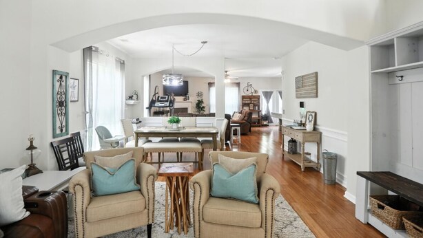 A spacious living area with a dining table, two armchairs, a sofa, and a kitchen in the background. - Low country luxury near Palmetto Bluff (Bluffton)