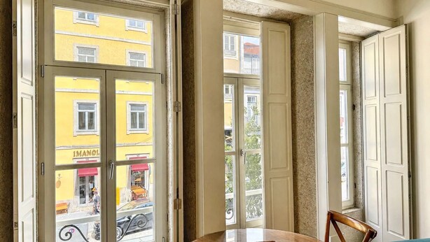 Una stanza con vista su un edificio giallo, un tavolo e una sedia.