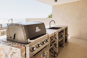 An outdoor kitchen with a Broil King grill, a sink, and a tiled backsplash. - Luxury Villa for 14 with 2 Pools, Sauna & Sea View (Ičići)