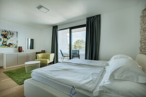 A modern hotel room with a bed, a desk, a chair, and a view of the outdoors. - Luxury Villa for 14 with 2 Pools, Sauna & Sea View (Ičići)