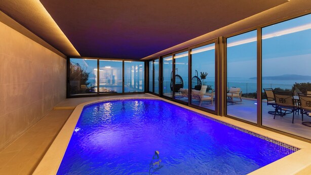 A swimming pool with a view of the cityscape at dusk. - Luxury Villa for 14 with 2 Pools, Sauna & Sea View (Ičići)