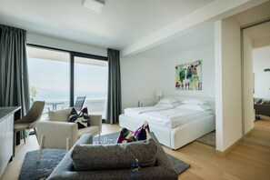 A modern hotel room with a bed, a desk, a chair, and a large window offering a view. - Luxury Villa for 14 with 2 Pools, Sauna & Sea View (Ičići)