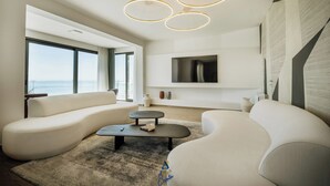 A modern living room with a large window, a flat-screen TV, and a unique ceiling light fixture. - Luxury Villa for 14 with 2 Pools, Sauna & Sea View (Ičići)