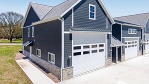 A two-story house with a garage, a small porch, and a well-maintained lawn. - Sturgeon Bay Boat Condo w Marina Slip (Sturgeon Bay)