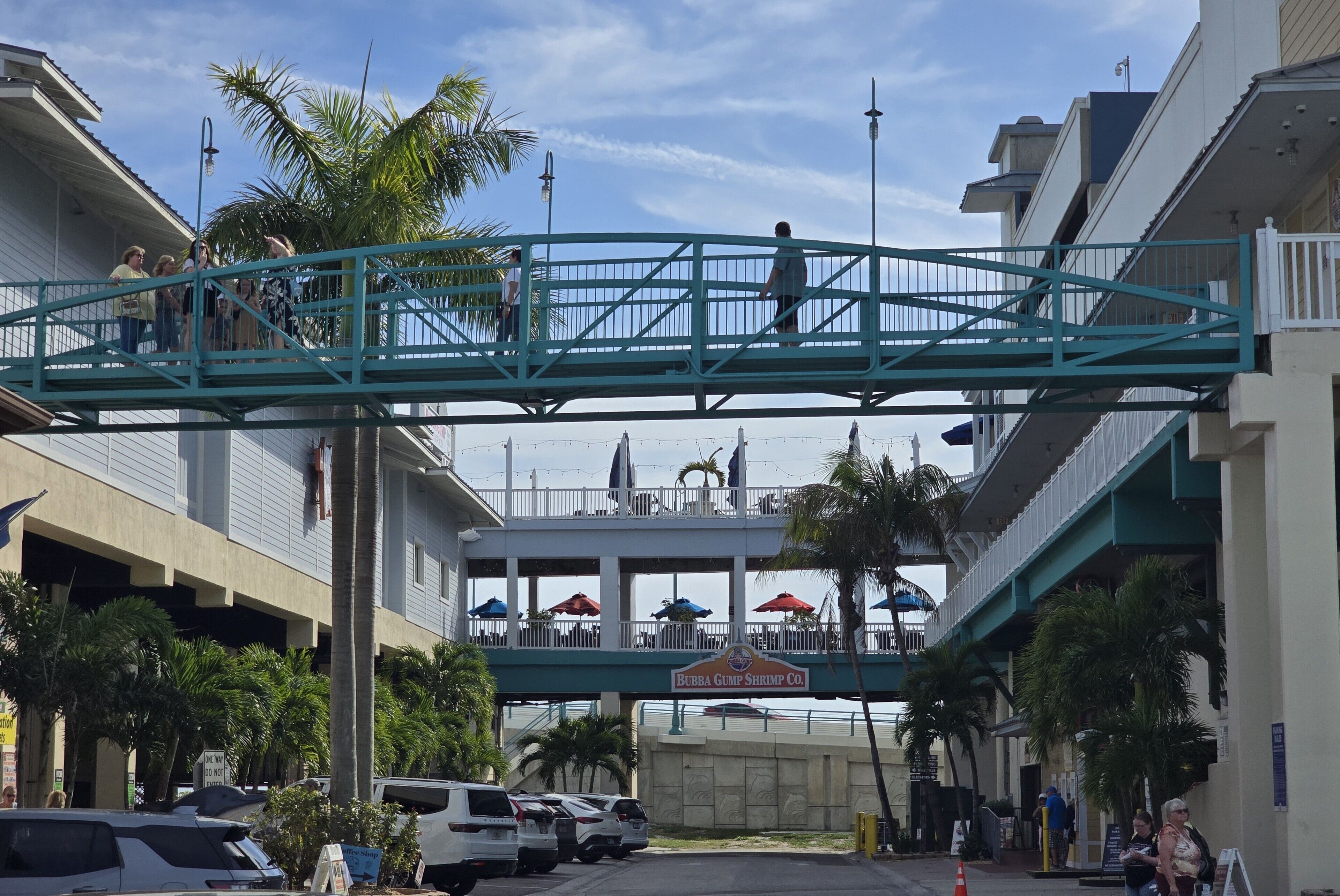 A pedestrian bridge over a parking area with a sign for Bubba Gump Shrimp Co.