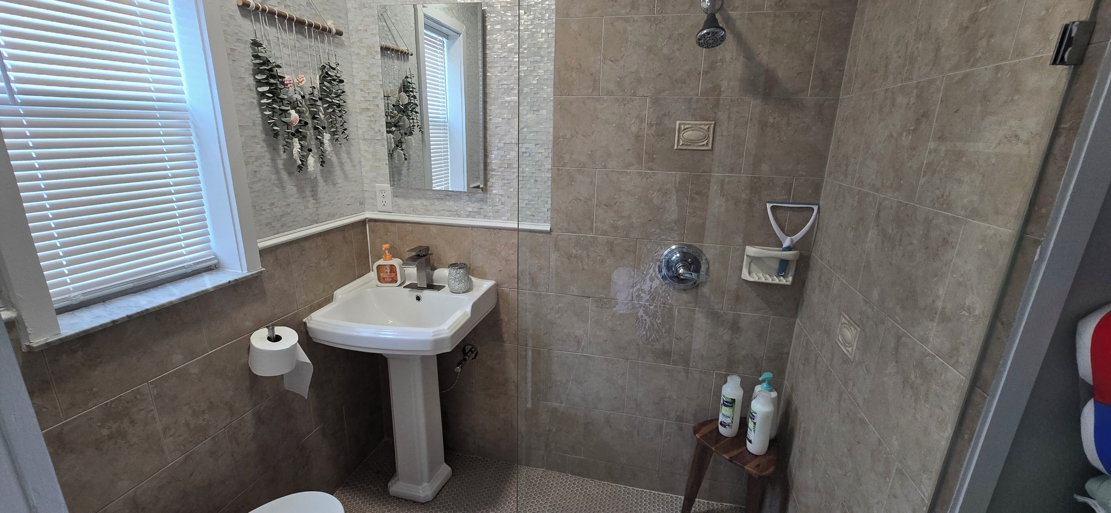 Ein Badezimmer mit Waschbecken, Toilette, Dusche und Spiegel.