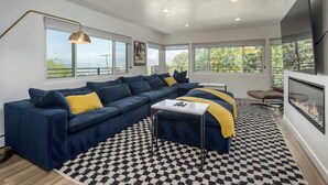 Ein modernes Wohnzimmer mit einem Ecksofa, einem Couchtisch und einem Kamin.