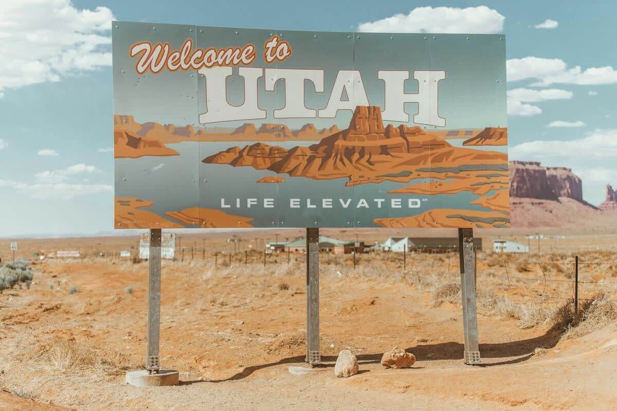 Welkomstbord voor Utah met een woestijnlandschap op de achtergrond.