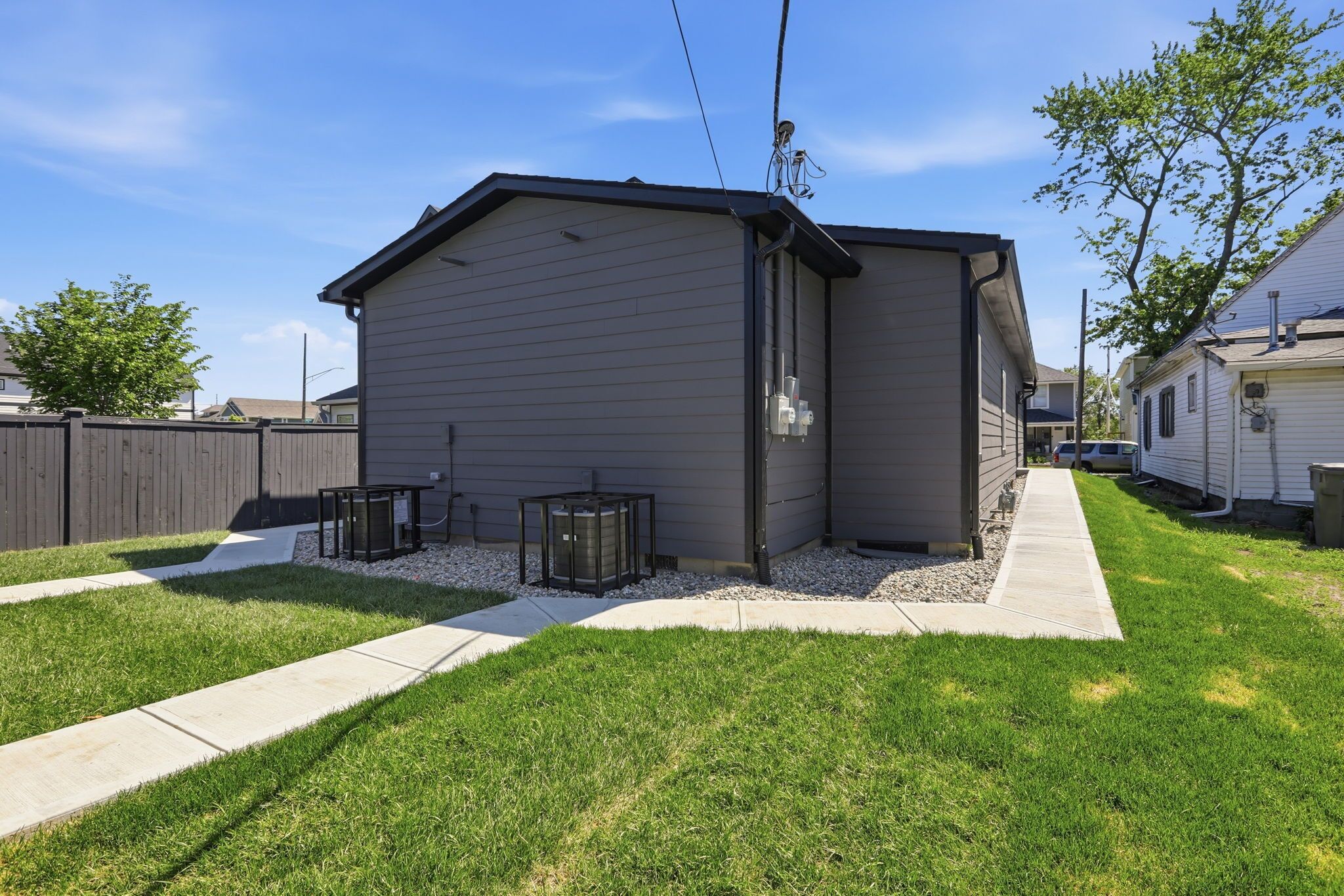 A residential building with a sloped roof, a small attached garage, and a paved driveway.