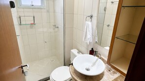Une salle de bain comprenant des toilettes, un lavabo, une douche et une fenêtre.