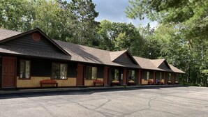 A row of cabins with a large parking lot in front.