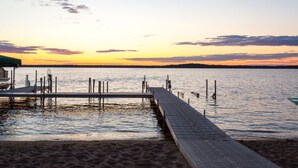 A pier extending into calm water with a sunset in the background.