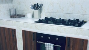 A kitchen with a stove, oven, and cabinets. - Cozy apartment with a large terrace (Libreville)