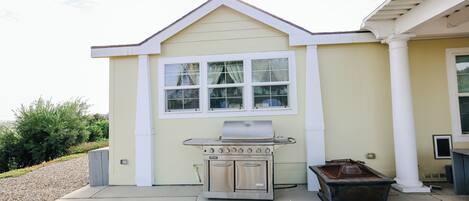 A house with a built-in outdoor grill, a window, and a small shed.