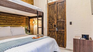 A bedroom with a bunk bed, a wooden door, a bedside table with a lamp, and a small desk with a coffee machine. - Casa Boutique WeLoft  San Antonio Cali (Cali)