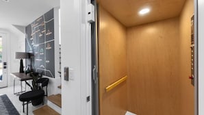 Ein Aufzug mit Holzvertäfelung und einem Metallgriff.