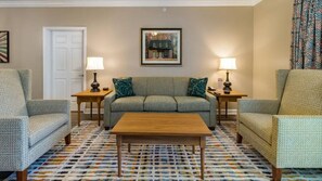 A living room with a sofa, two armchairs, a coffee table, and patterned floor. - Colonial Comfort: 3BR Lock-Off Villa with Fireplace & Full Kitchen (Williamsburg)