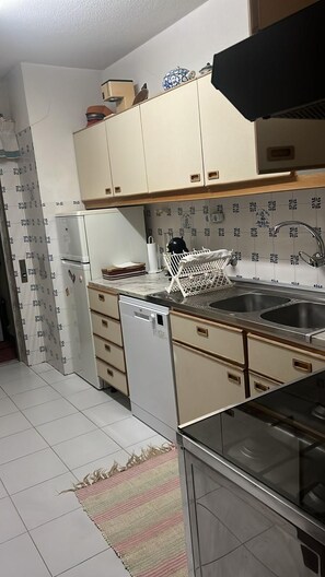 A kitchen with a dishwasher, double sink, and cabinets. - Portimão Beach Apartment (Portimão)