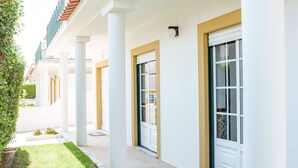 A building with a covered walkway, columns, and doors. - Maison du Bonheur, Garden Peace (Peniche)