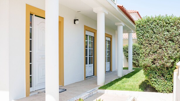 A building with white exterior walls, yellow trim, and a covered porch with columns. - Maison du Bonheur, Garden Peace (Peniche)
