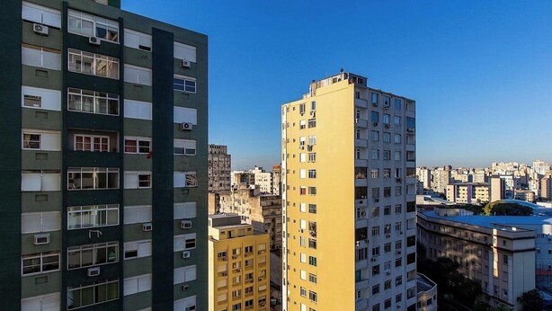 Un immeuble de grande hauteur, doté de nombreux étages, de grandes fenêtres et de climatiseurs.