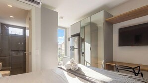 A hotel room with a bed, a desk, a television, and a wardrobe. - Modern Studio in Moema Ois10623 (São Paulo)