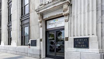 Un immeuble avec une enseigne indiquant « Bluegreen Vacations », une plaque commémorative pour l’« American Trust Building » et une caméra de surveillance.