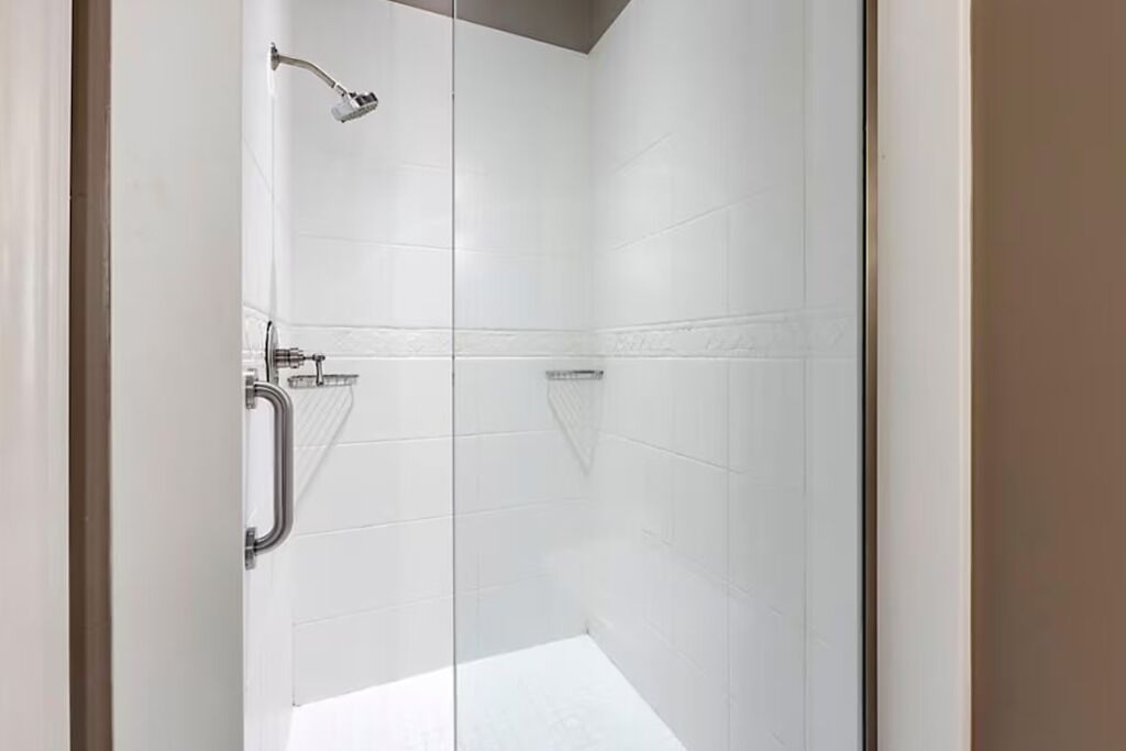 Une douche équipée d’un pommeau de douche à main, d’un autre pommeau de douche à main et d’un troisième pommeau de douche à main.
