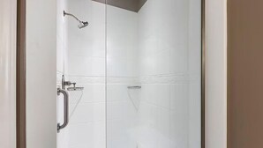 Une douche équipée d’un pommeau de douche à main, d’un autre pommeau de douche à main et d’un troisième pommeau de douche à main.