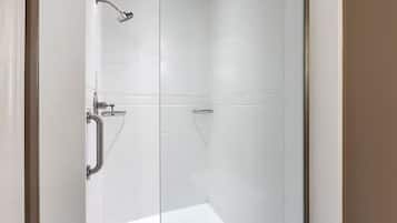 Une douche équipée d’un pommeau de douche à main, d’un autre pommeau de douche à main et d’un troisième pommeau de douche à main.