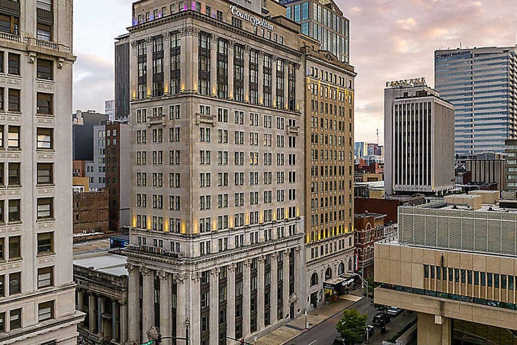 Un immeuble à plusieurs étages, de style architectural classique, doté de grandes fenêtres et d’une entrée imposante.