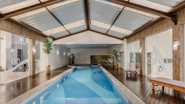 An indoor swimming pool with a high ceiling and wooden flooring. - Studio in Condo. w/ Pool in Downtown Nwc1007 (Curitiba)