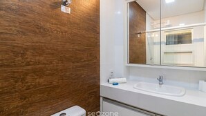A bathroom with a wooden wall, a white sink, and a mirror. - Apt. in Condo. in Pereque, Porto Belo Cid0102 (Porto Belo)