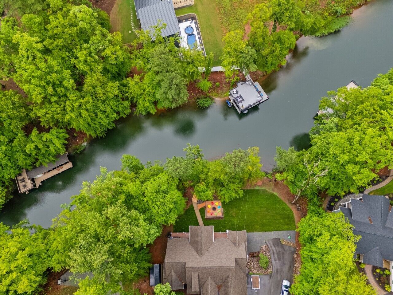 Luchtbeeld van een woongebied met een huis, een steiger en een zwembad.