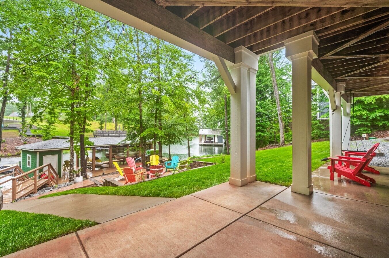 A covered patio area with outdoor seating, a small dock, and a pond.
