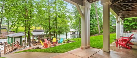 A covered patio area with outdoor seating, a small dock, and a pond.