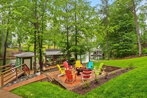 Eine Terrasse mit Sitzgelegenheiten im Freien, einer Feuerstelle und einem kleinen Schuppen.