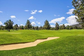 A golf course with sand bunkers, trees, and a clear sky. - Spacious Eagle Crest Condo with Resort Perks (Redmond)