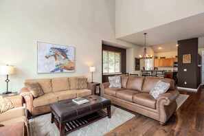 A spacious living room with two leather sofas, a coffee table, and a large abstract painting. - Spacious Eagle Crest Condo with Resort Perks (Redmond)
