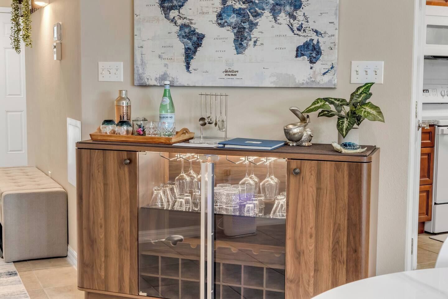 A wooden bar area with a world map, a bottle, and a plant.