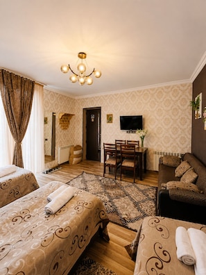 Habitación cuádruple Confort, vista al jardín | Área de sala de estar