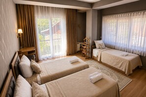 A hotel room with two beds, a desk, a chair, and a view of the outdoors. - Sheki Secret Garden (Sheki)